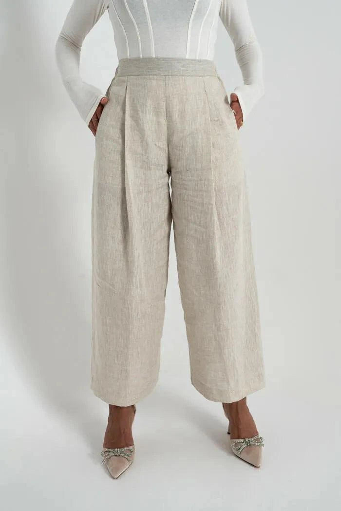 Beige linen pants with wide legs worn with white top and heels