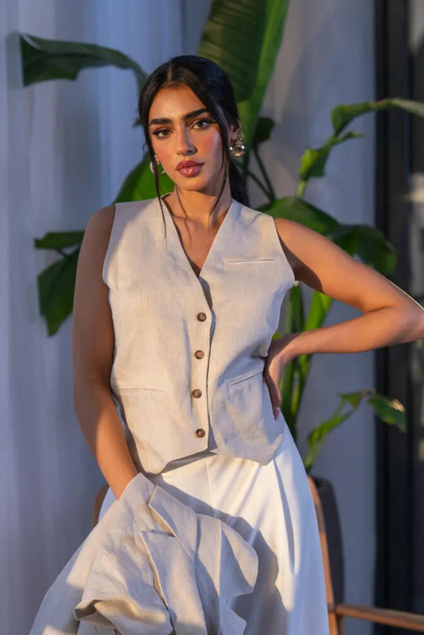 woman wearing tailored beige linen vest with four front buttons and subtle false pockets