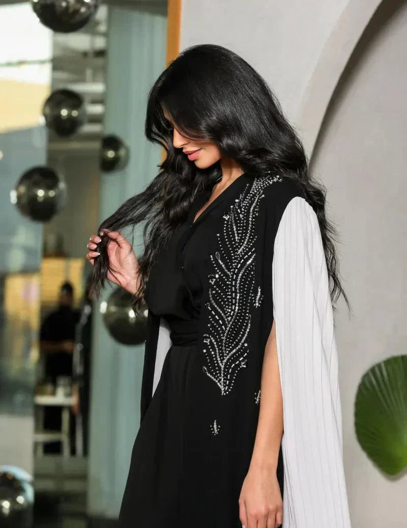 black crepe abaya with white pleated side panels and silver bead embroidery in a leaf pattern