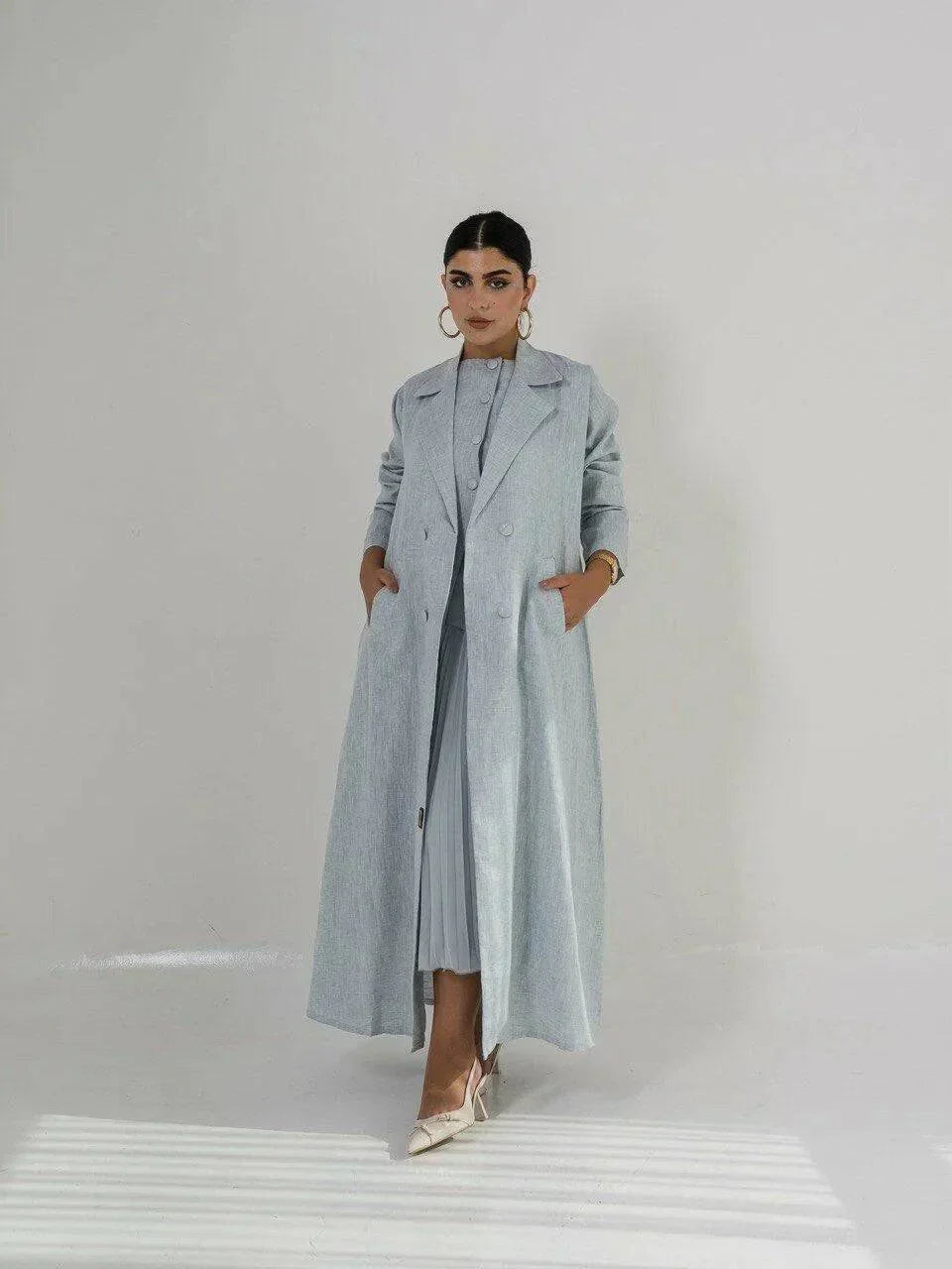 Full-length light blue linen coat with sharp lapel collar, double-breasted front, and side pockets, featuring a structured silhouette - full-length coat