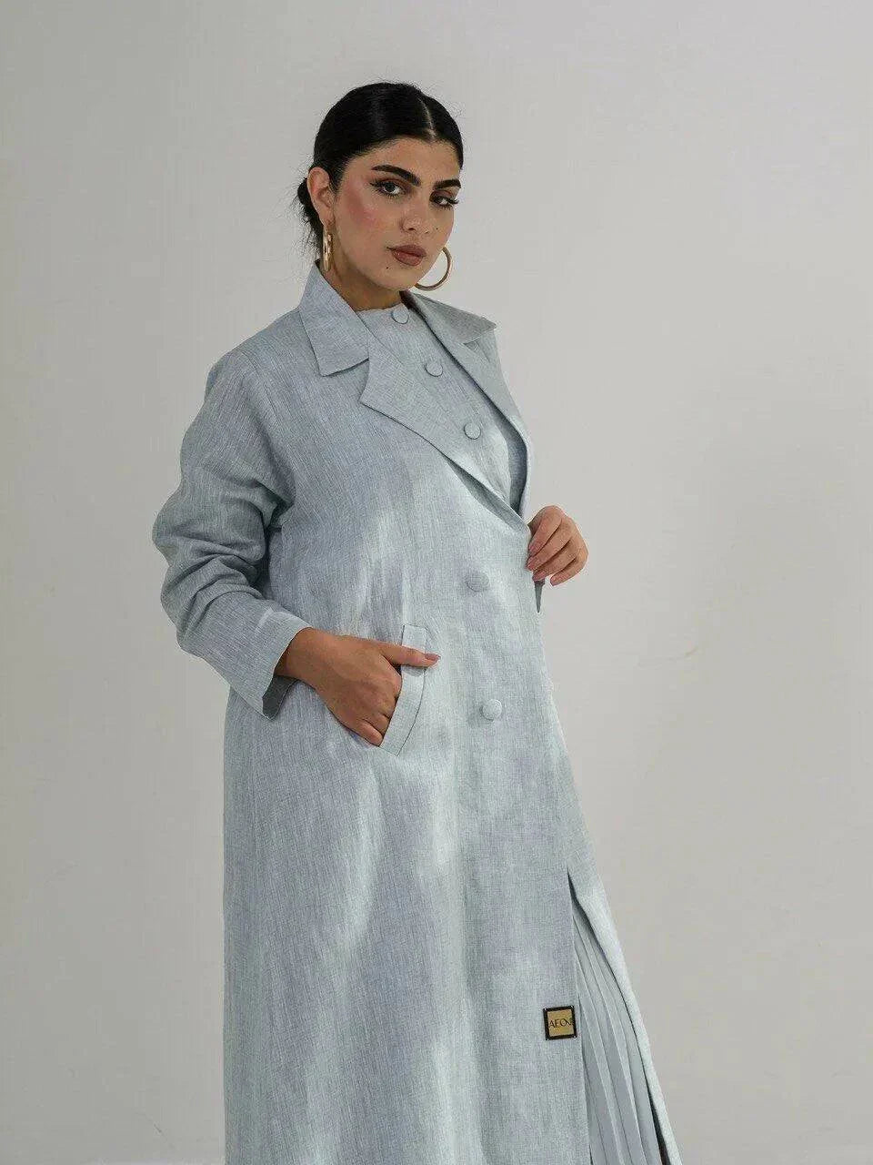 Full-length light blue linen coat with sharp lapel collar, double-breasted front, and side pockets, featuring a structured silhouette - full-length coat