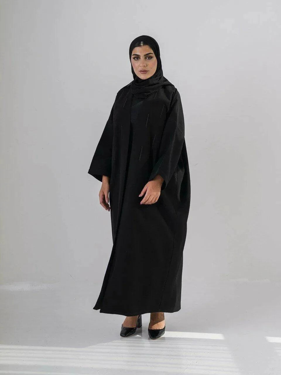Elegant black abaya with subtle front embroidery, made from high-quality crepe for year-round comfort and versatile wear