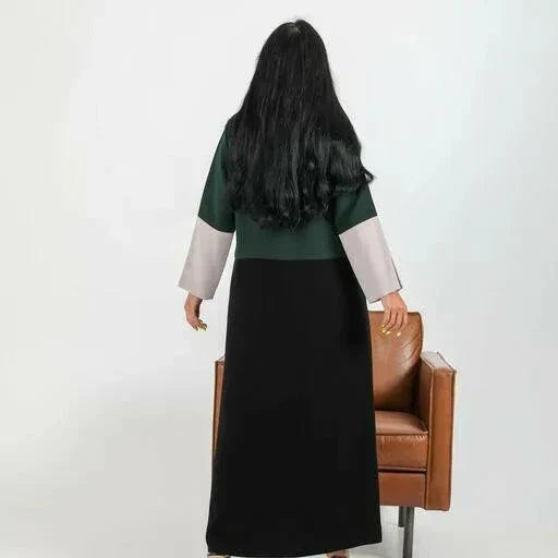 Color-blocked crepe blazer abaya with forest green body, black lapels, and grey sleeve cuffs over a flowy black base.