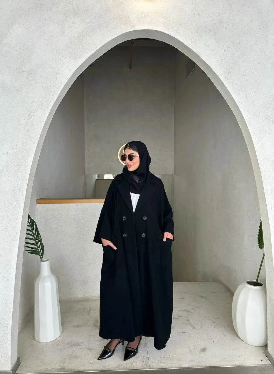 freesize black abaya in soft crepe fabric with front buttons and relaxed fit worn by woman in modern minimalist setting