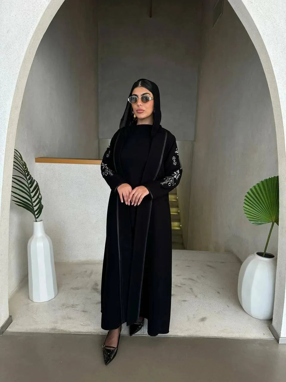 timeless black abaya in soft crepe fabric with delicate embroidery on sleeves, elegant and simple silhouette