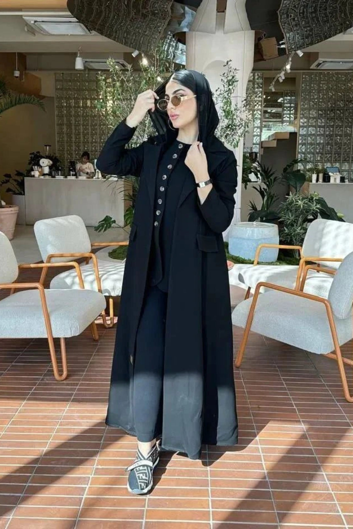 woman wearing a classic black blazer made of smooth crepe fabric in a modern indoor setting