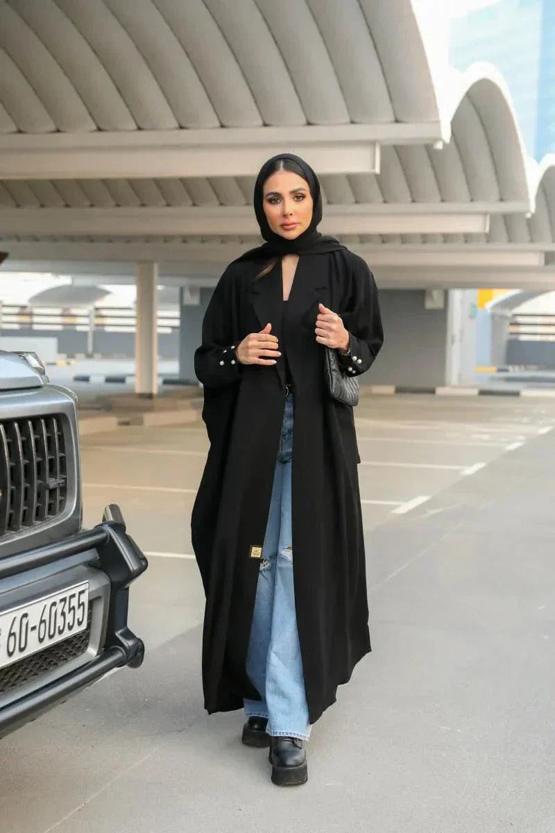 woman wearing classic black abaya with soft crepe fabric draped elegantly outdoors near car