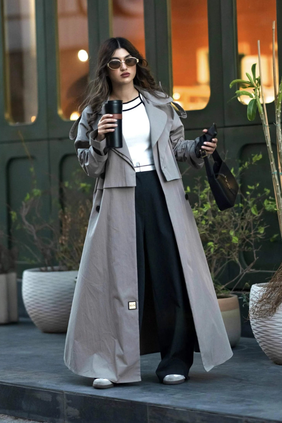 woman wearing modern classic trench coat with wide lapel collar and flowing silhouette outdoors