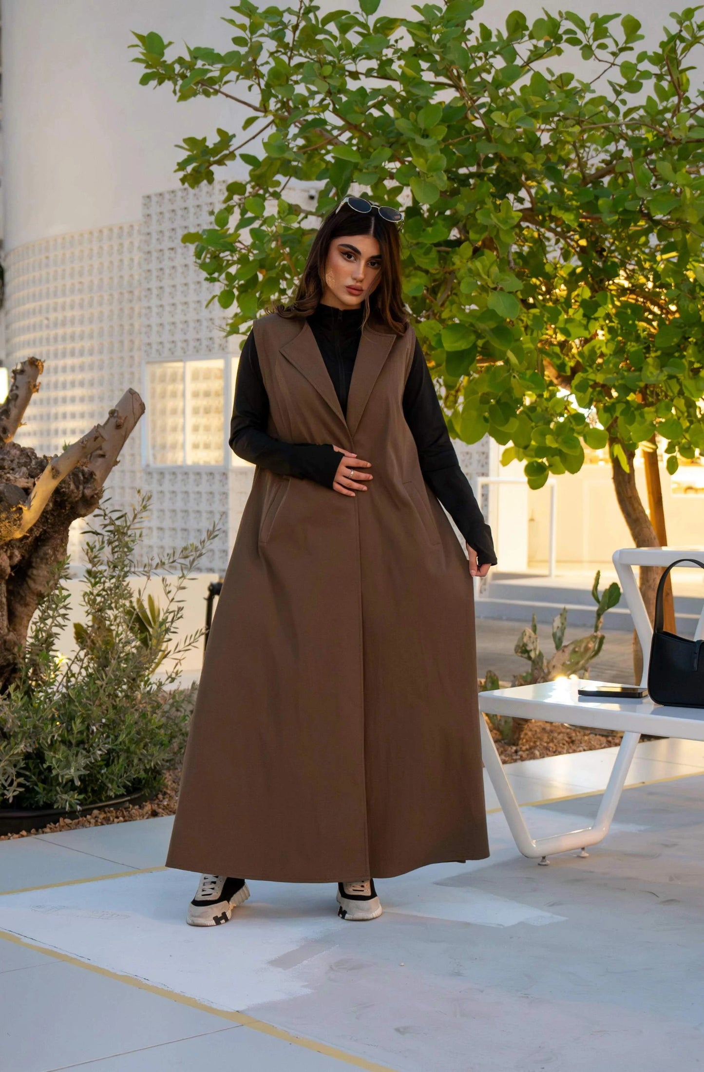 woman wearing chino brown cropped trench over sleeveless dress outdoors