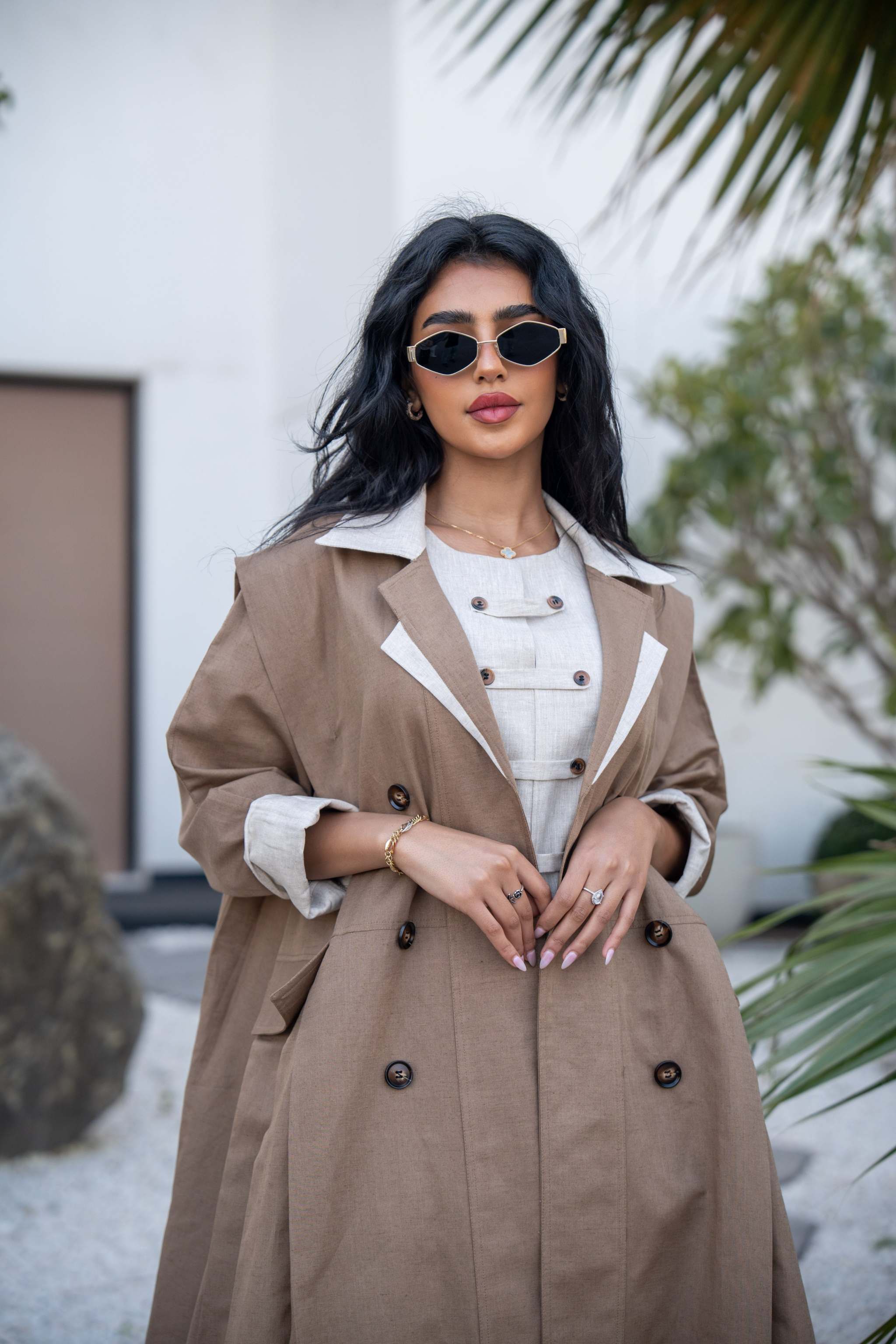 Woman wearing Creme Caramel two-tone mocha brown abaya with off-white lapels and double-breasted design outdoors