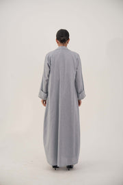 Back view of a lightweight blueish gray long abaya blazer with wide embellished cuffs and a modern straight-cut design