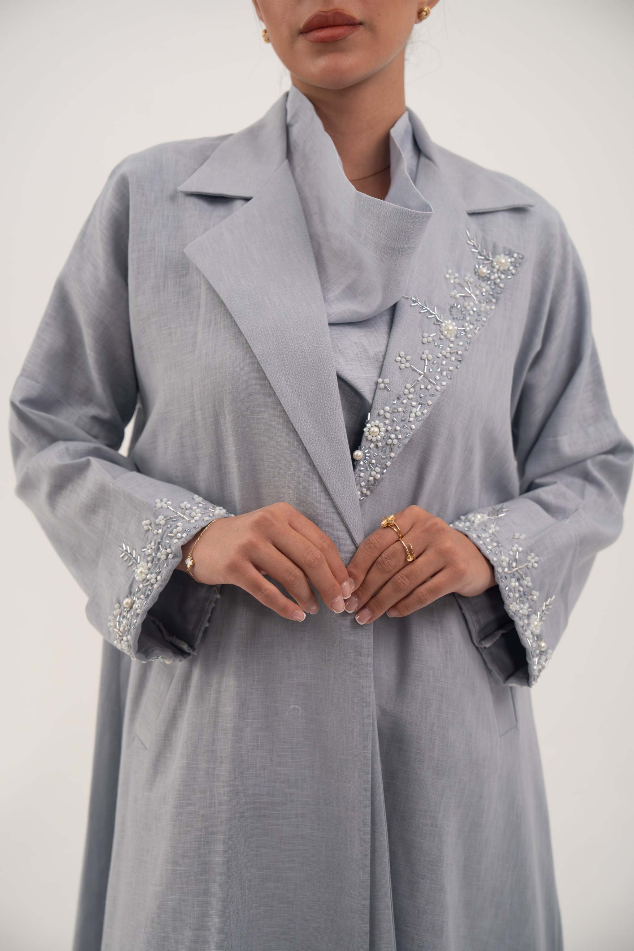 Lightweight blueish gray blazer-style abaya with wide lapel and delicate white bead and crystal embellishments on lapel and cuffs.
