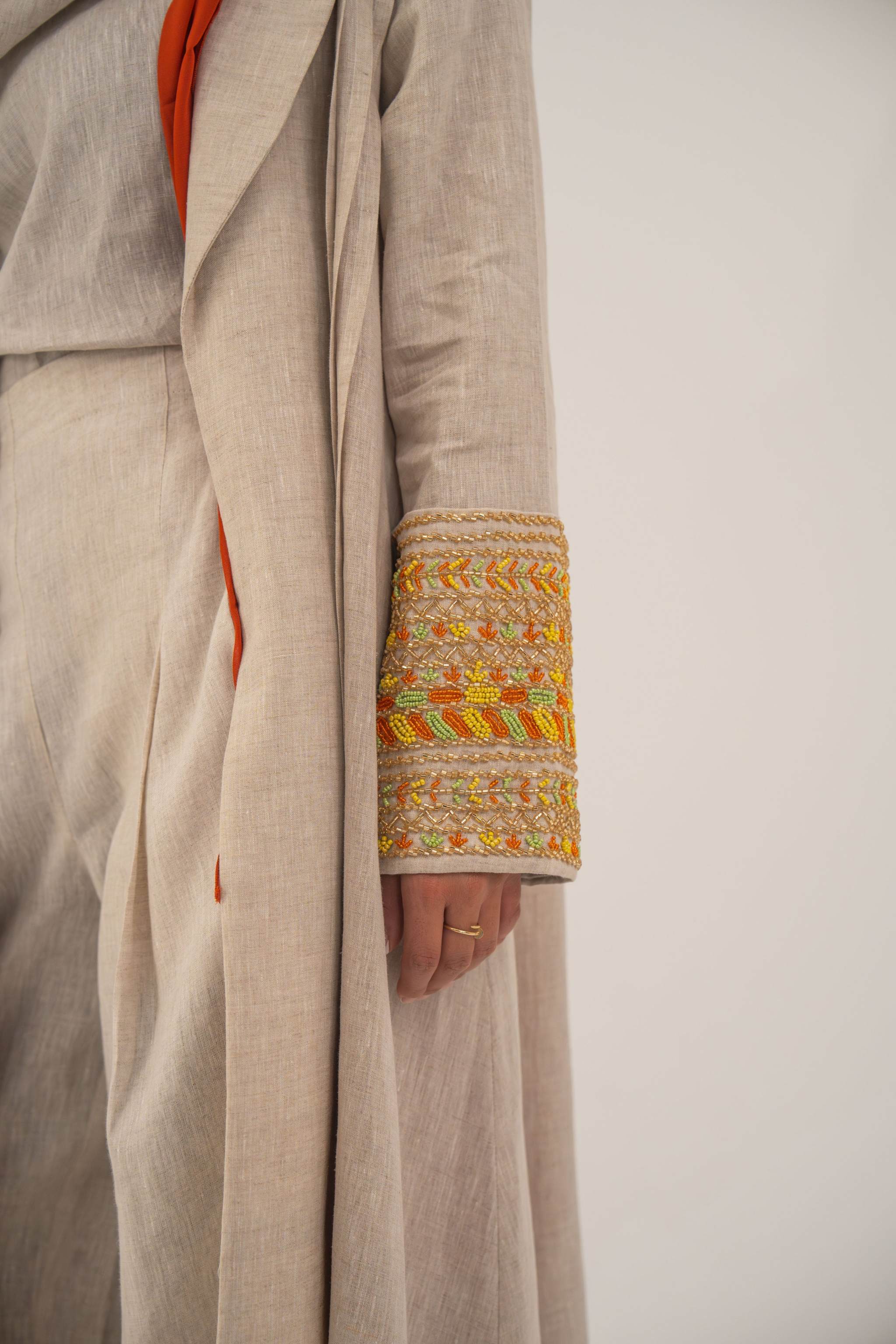 Beige linen blend abaya with tailored blazer cut and vibrant orange, gold, and green embroidery on sleeves - sophisticated abaya