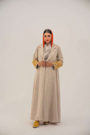 Beige linen blend abaya with blazer-style cut and vibrant orange, gold, and green shak embroidery on sleeves, featuring orange chiffon lining - sophisticated abaya