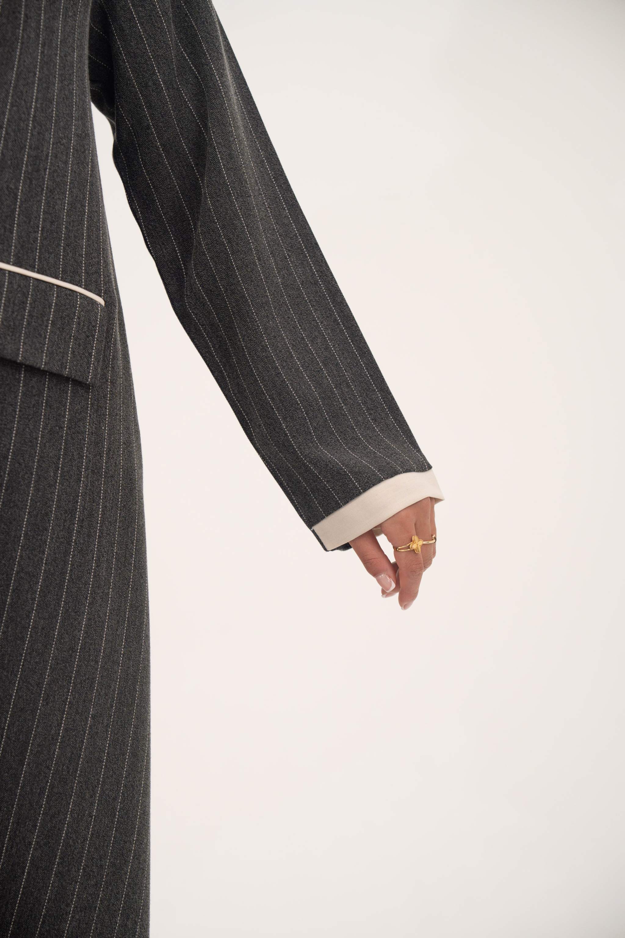 Sleeve detail of Ashmood pinstripe crepe blazer-style abaya with white cuff and subtle arm slit.