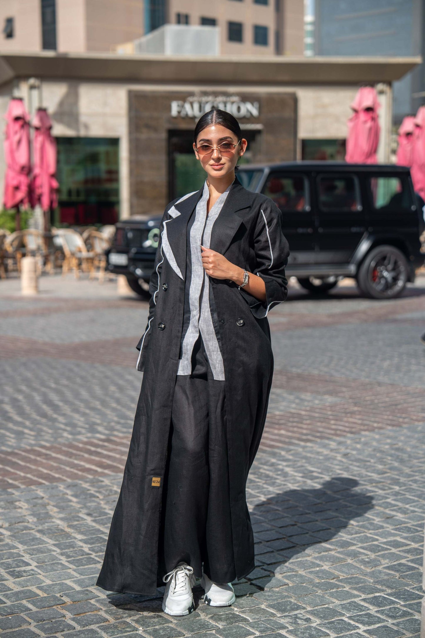 Black tailored blazer abaya with sharp lapels and bold white piping, styled for professional and casual wear.