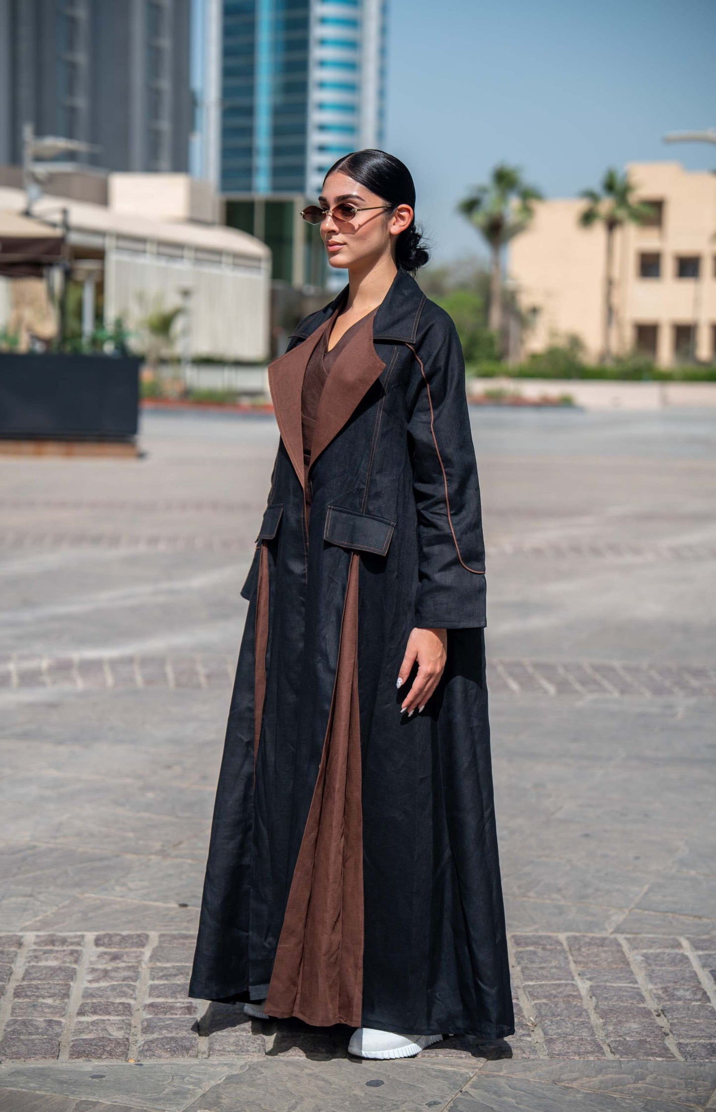 Woman wearing black and brown linen Velora abaya with wide lapels and structured street-style design outdoors
