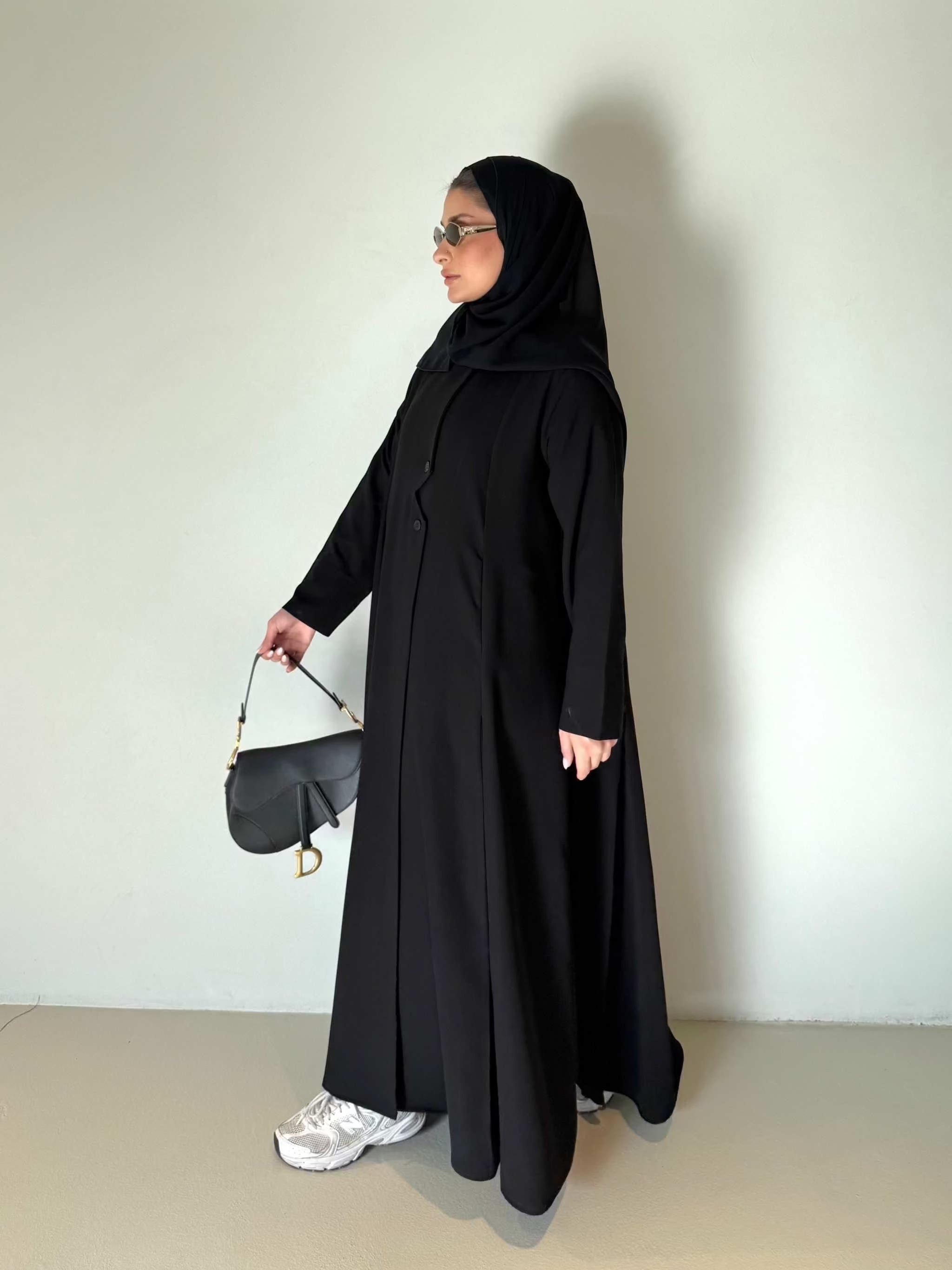 Black flowing crepe abaya with full button-down front, lightweight and elegant, styled with a black hijab and sunglasses.