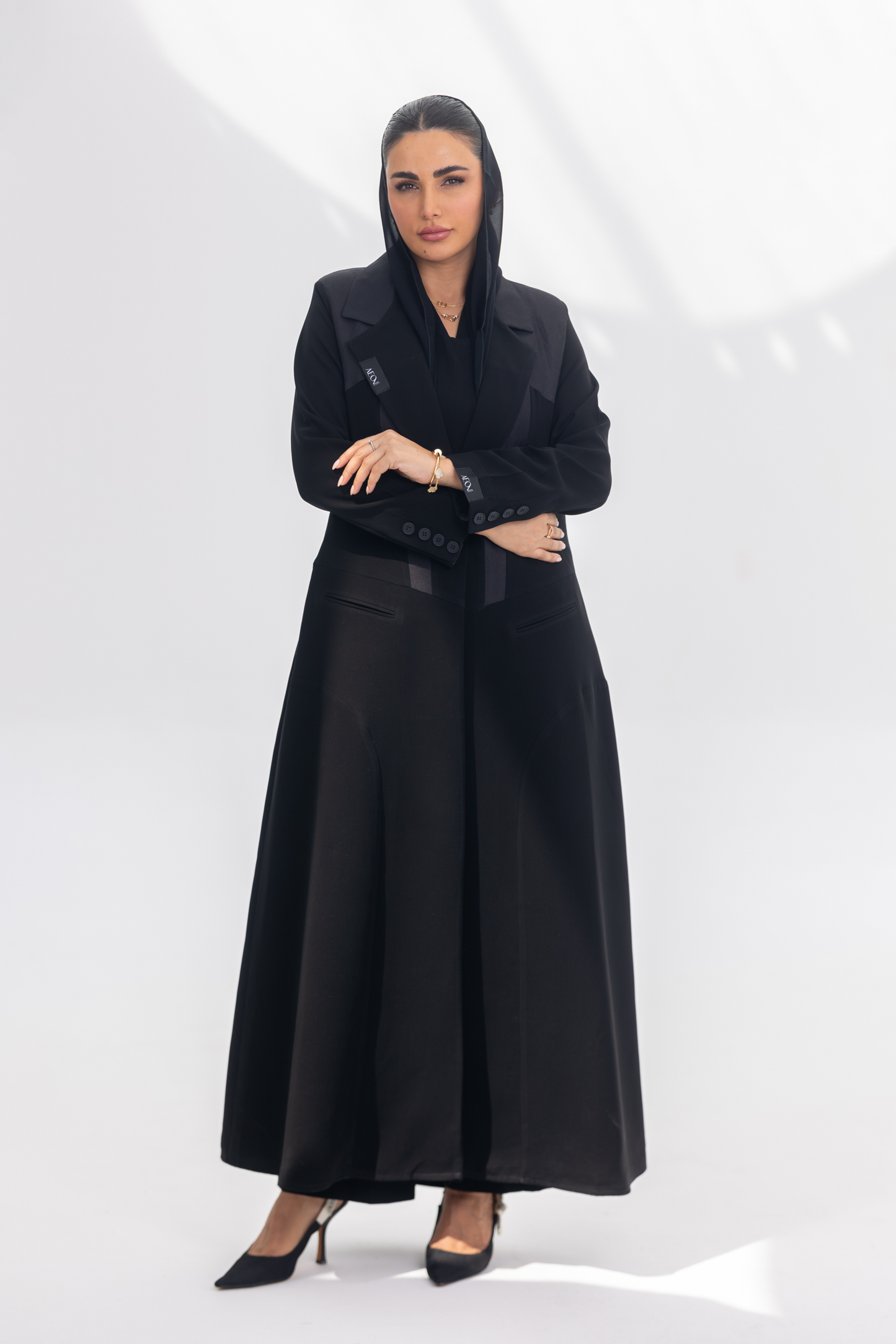 Woman wearing elegant black crepe front-open abaya with dark grey accents and silk lining, styled for modesty and comfort.