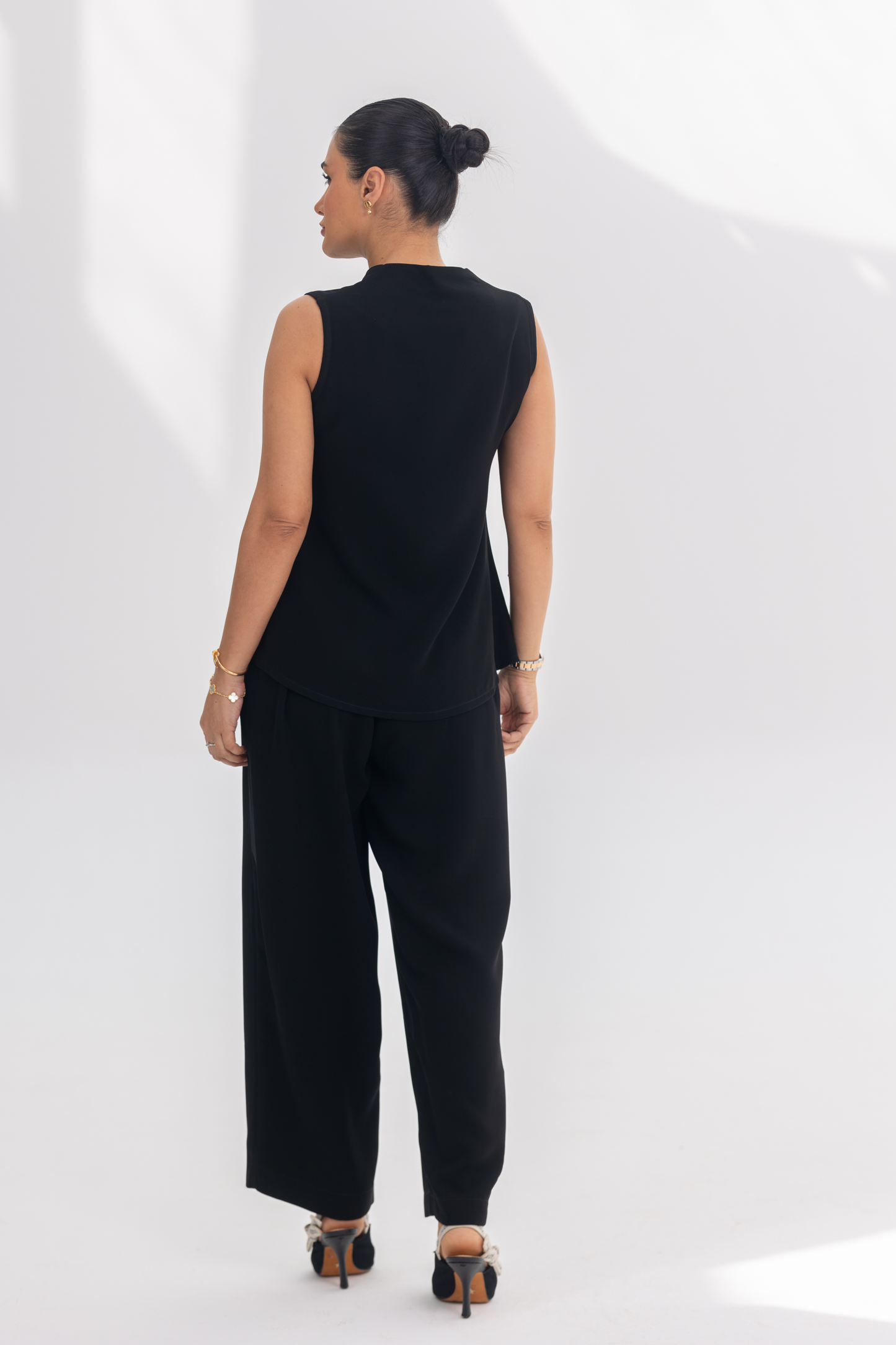 Woman wearing Noir Essential black crepe inner set with sleeveless top and wide-leg pants, styled for comfort and elegance.