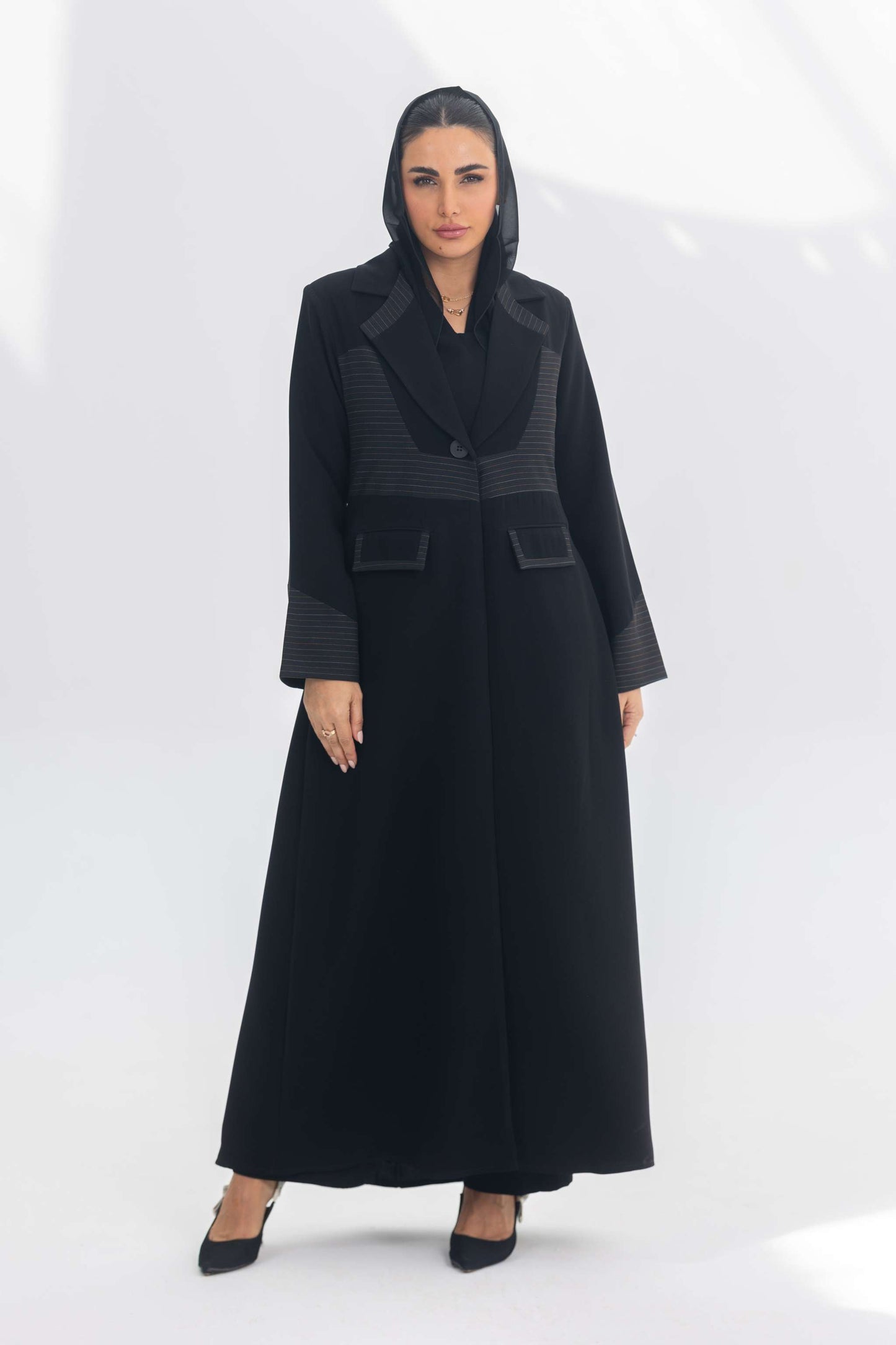 Elegant black crepe blazer abaya with contrasting texture and tailored silhouette worn by woman