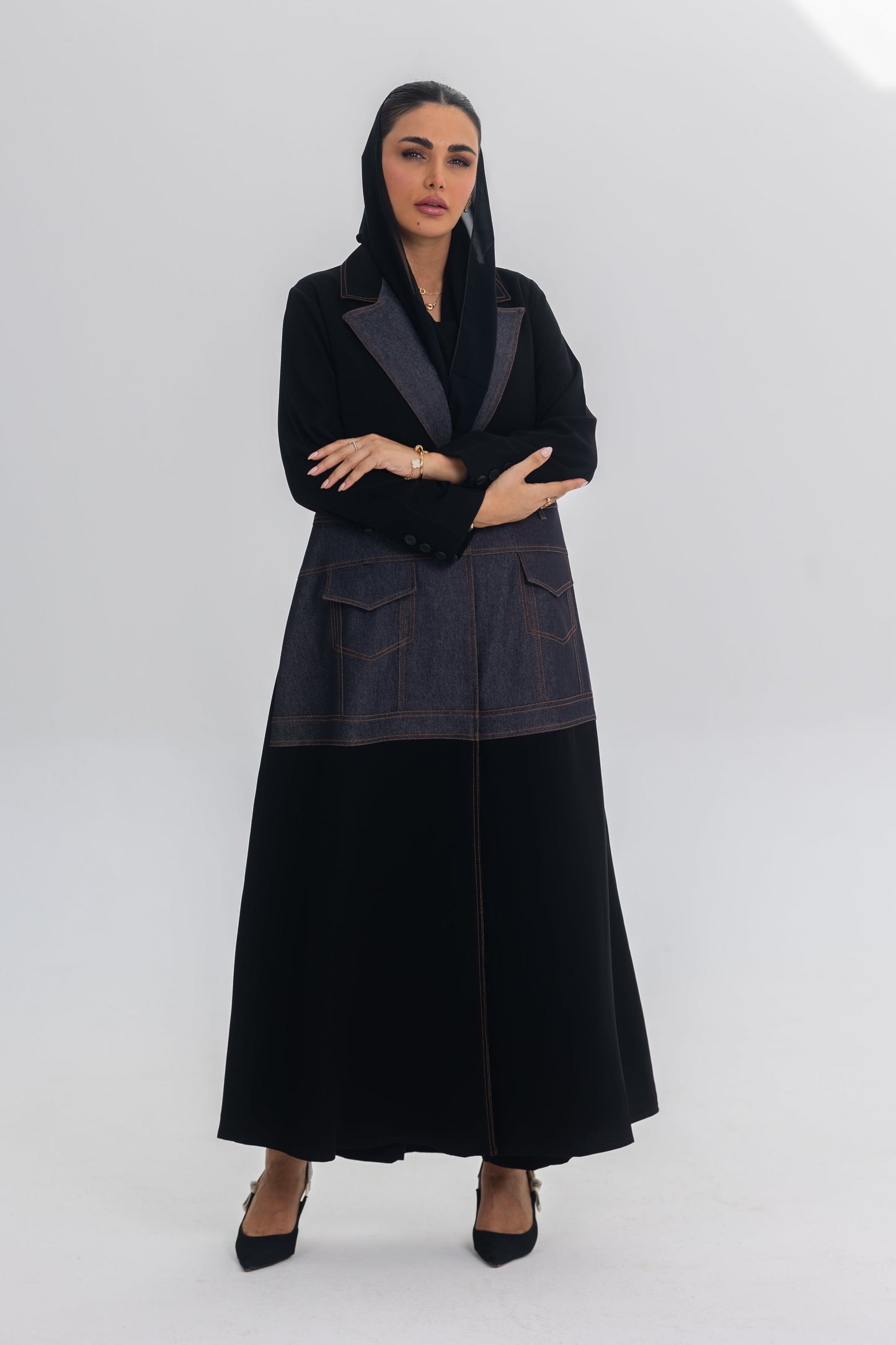 Woman wearing Blue Stitch abaya with black crepe and denim fabric fusion, modern and chic design