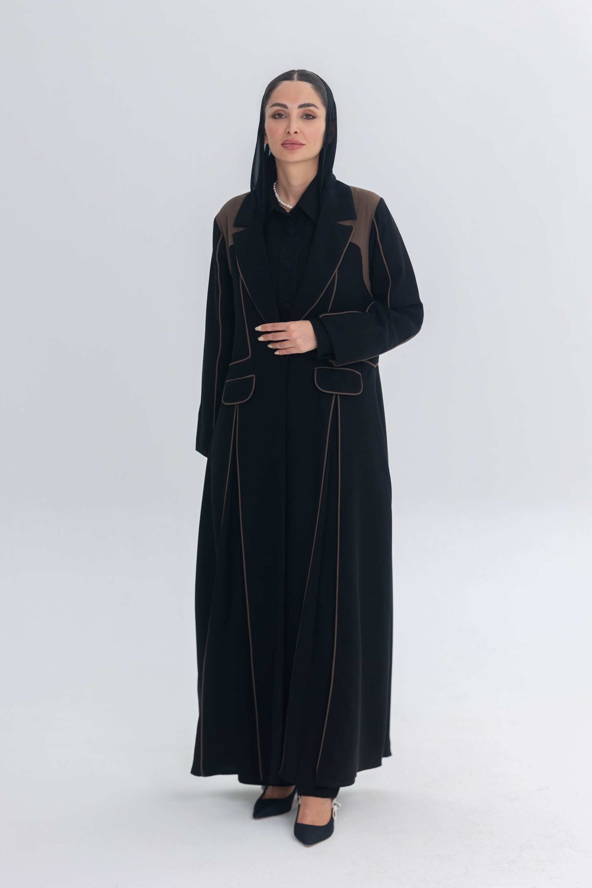 Woman wearing Cocoa Shadow black abaya with rich brown 3D detailing and elegant contrast design