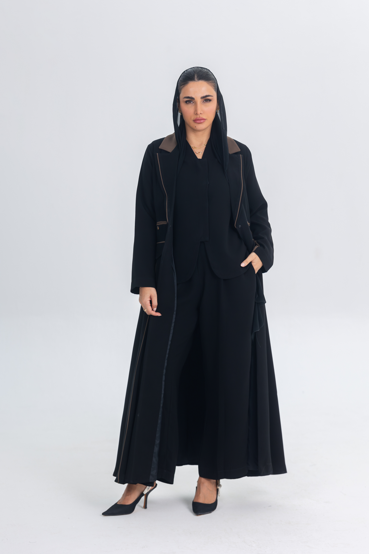 Woman wearing a black Chestnut Glow Abaya with brown brim details in a sleek blazer silhouette.