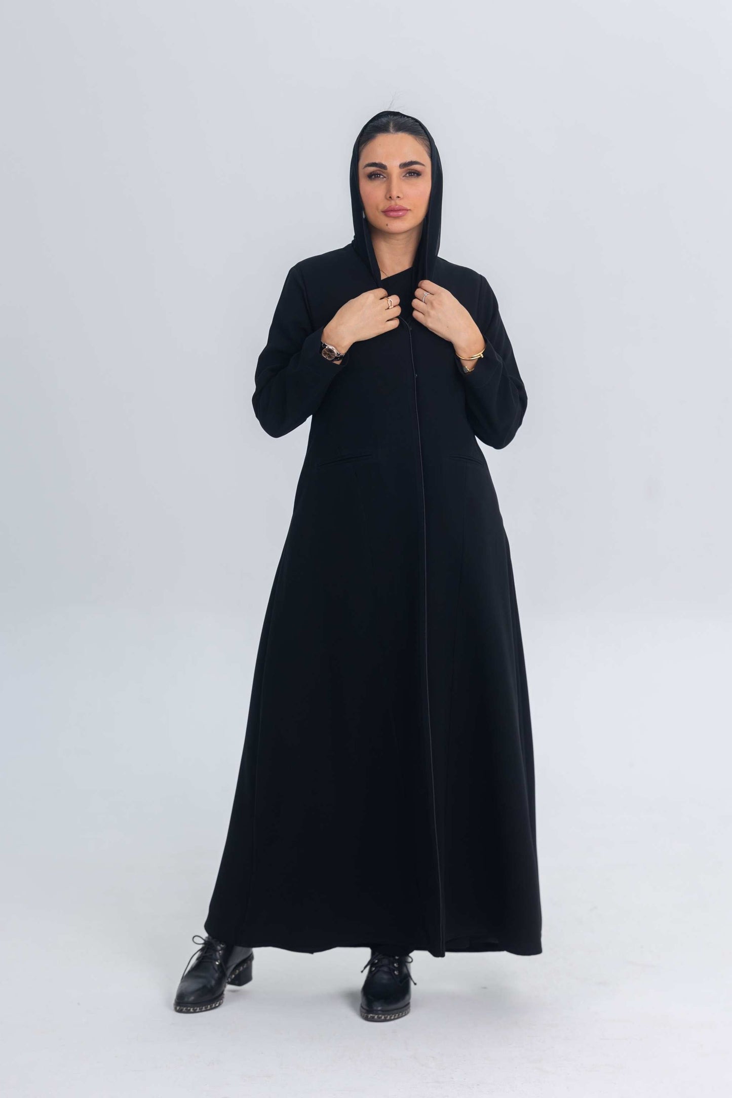 Woman wearing a black crepe abaya with subtle satin details, styled simply for versatile everyday wear