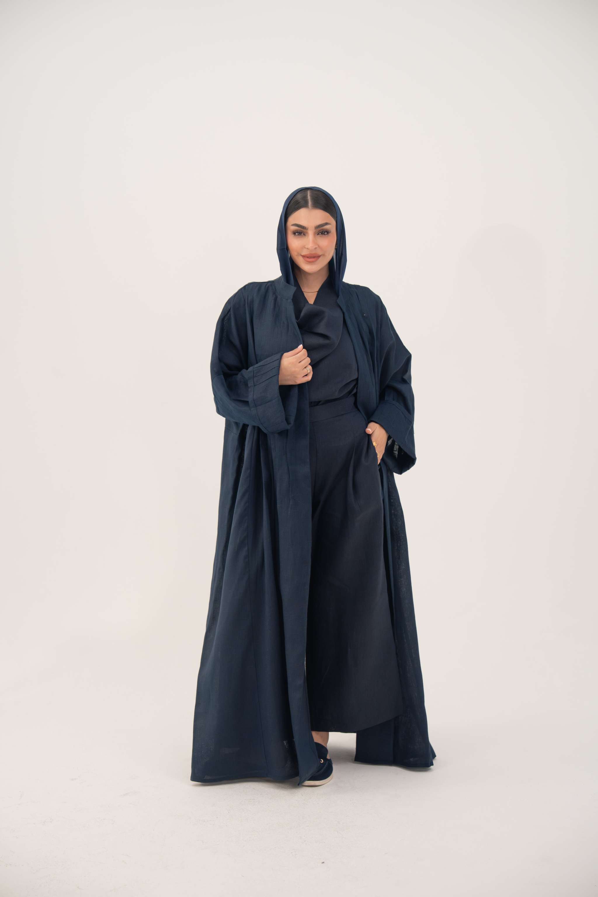 Woman wearing full-length open-front abaya navy blue linen with vertical stitched pleats
