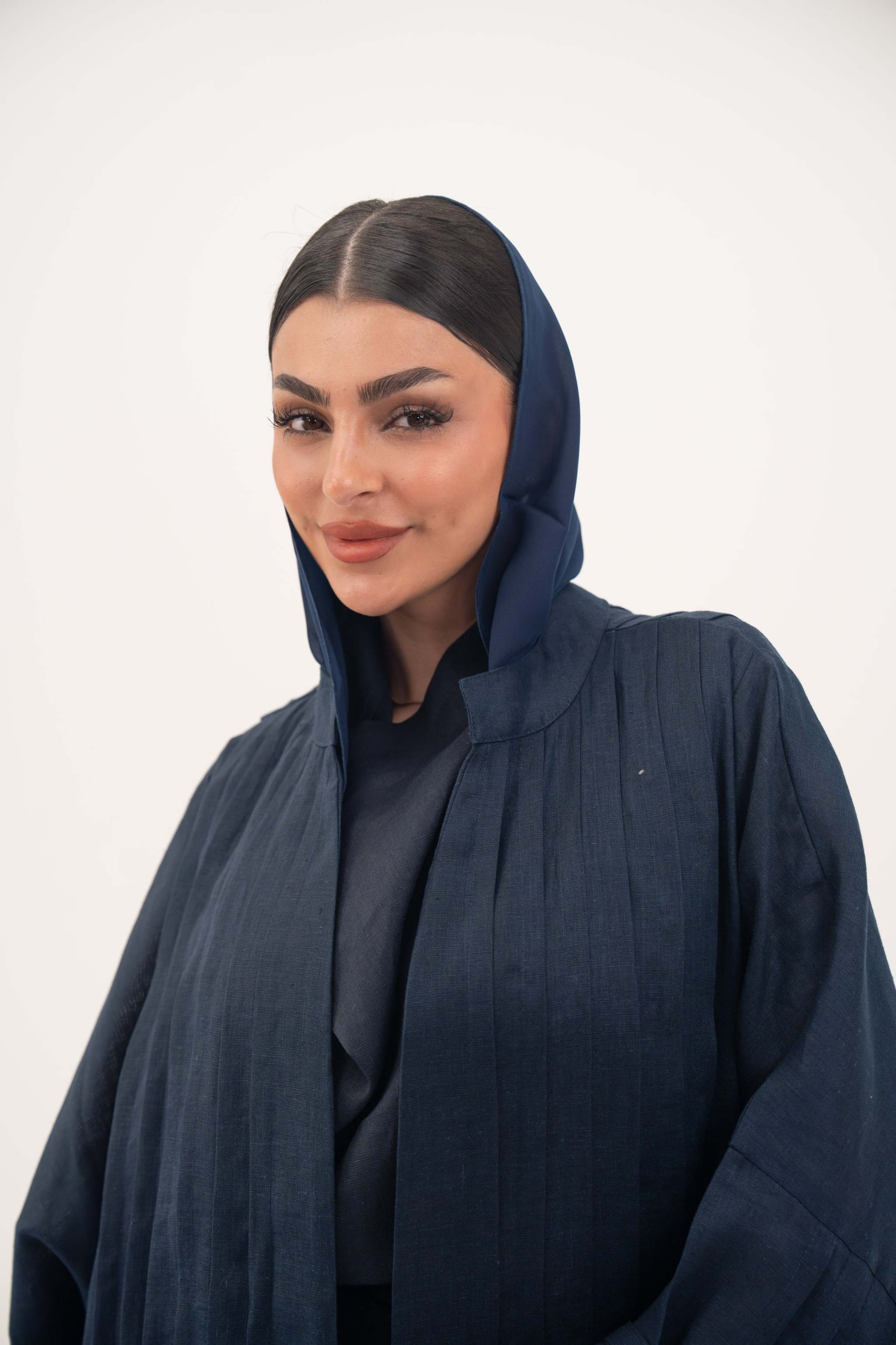 Woman wearing full-length open-front abaya navy blue linen with vertical stitched pleats