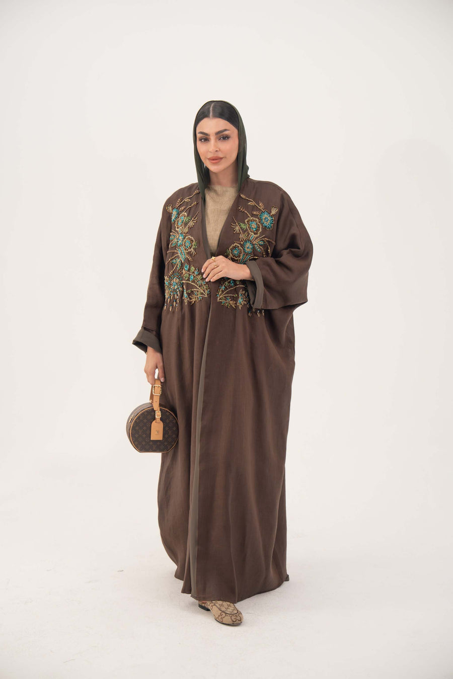 Brown bisht abaya with turquoise and gold floral embroidery and lightweight chiffon lining for elegant special occasions.