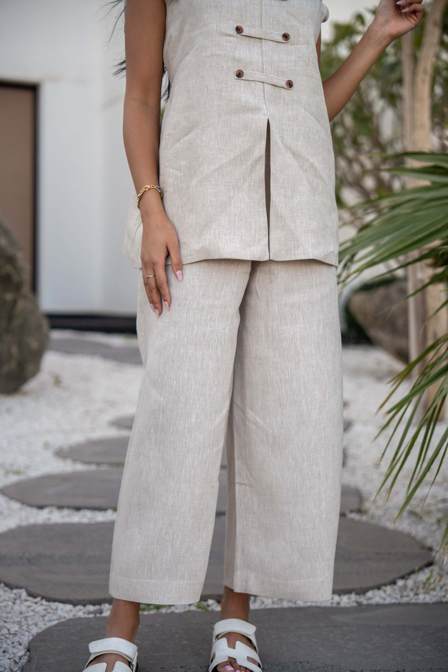 Beige Modern Pant with a structured waistband and button details, styled with white sandals.