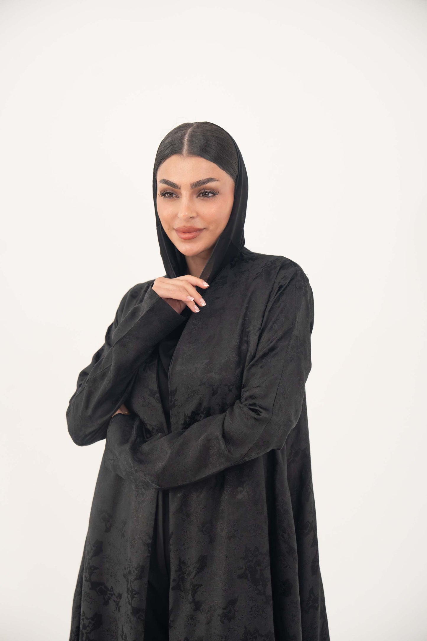 Elegant black jacquard silk abaya with tone-on-tone floral weave, A-line cut, open front, and hidden side pockets.