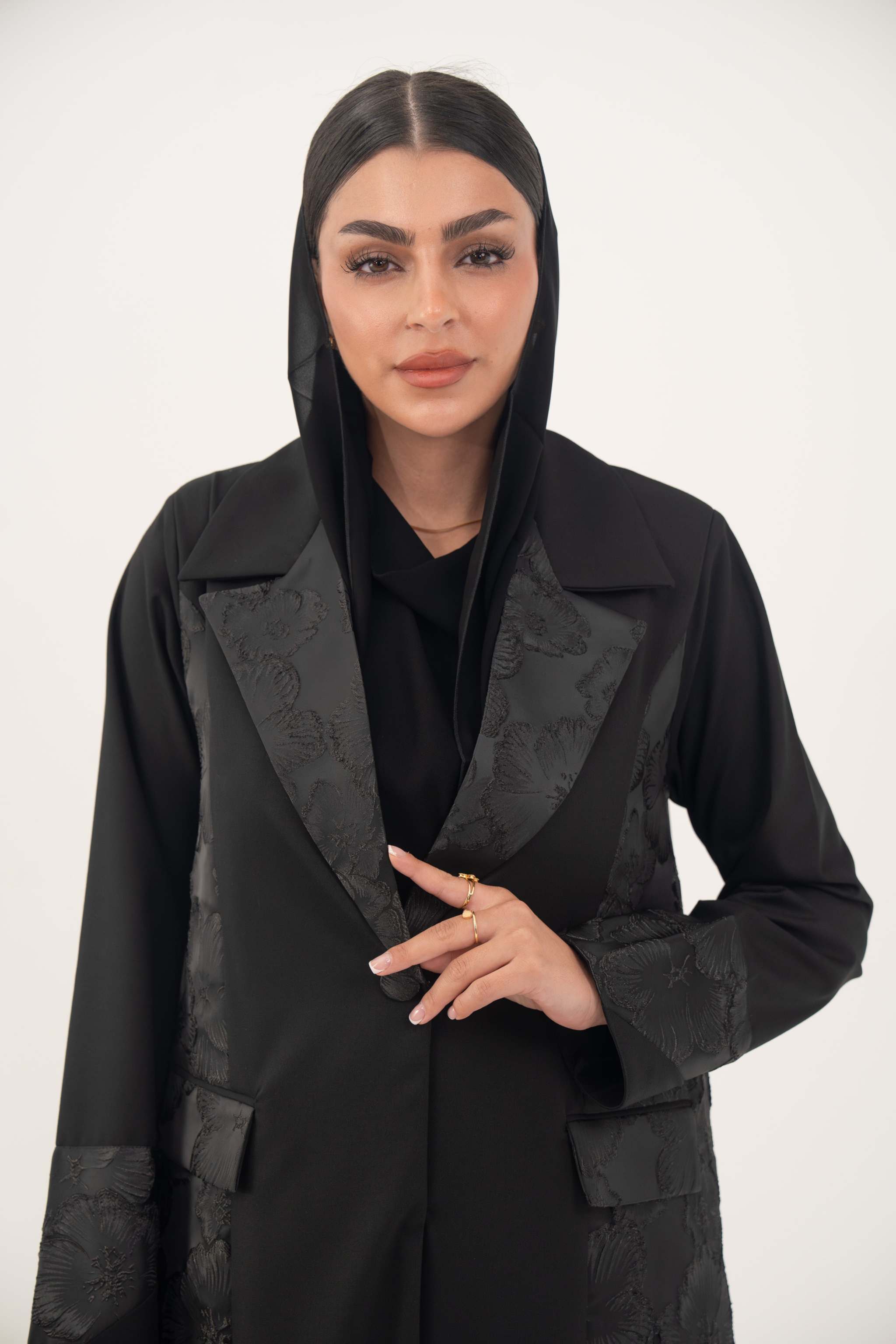 Black jacquard blazer abaya with textured pattern, structured silhouette, and classic lapels for formal wear.