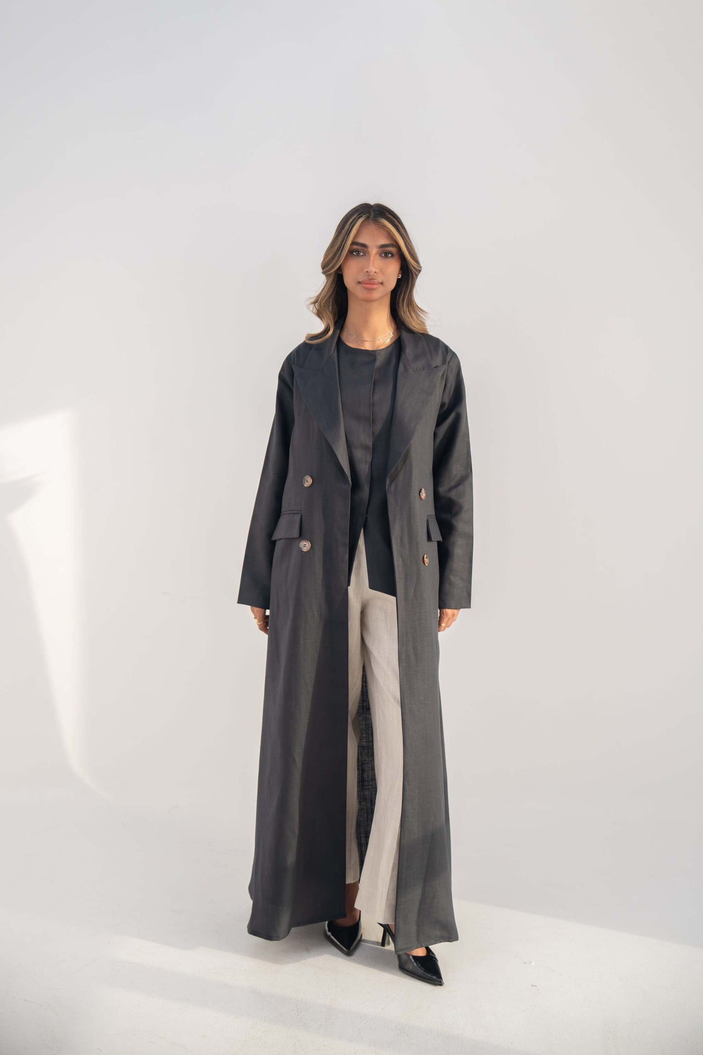 woman wearing long navy blue blazer abaya with double-breasted buttons and lapel collar