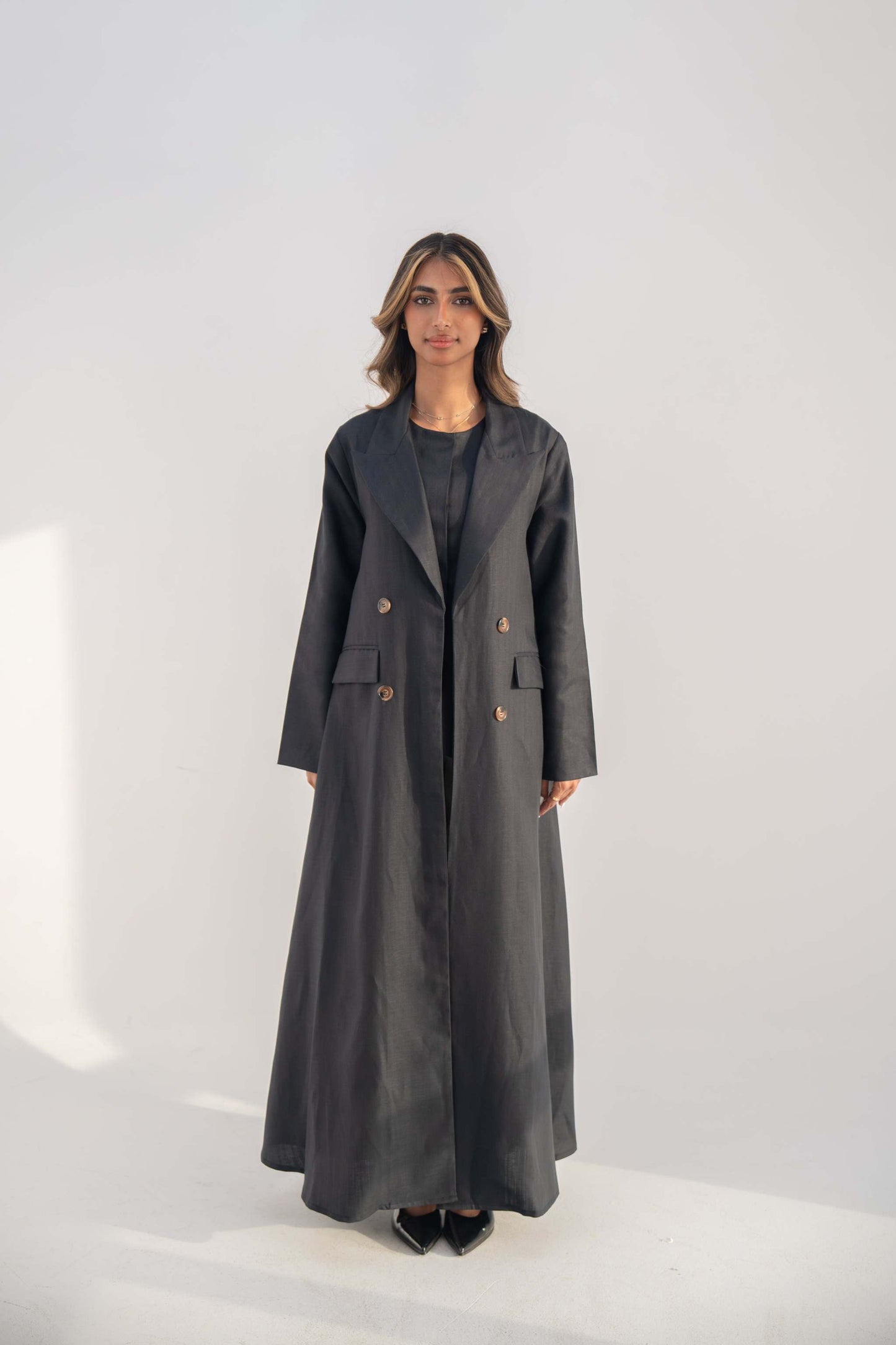 Navy blue double-breasted blazer abaya with lapel collar and flap pockets, long sleek silhouette.