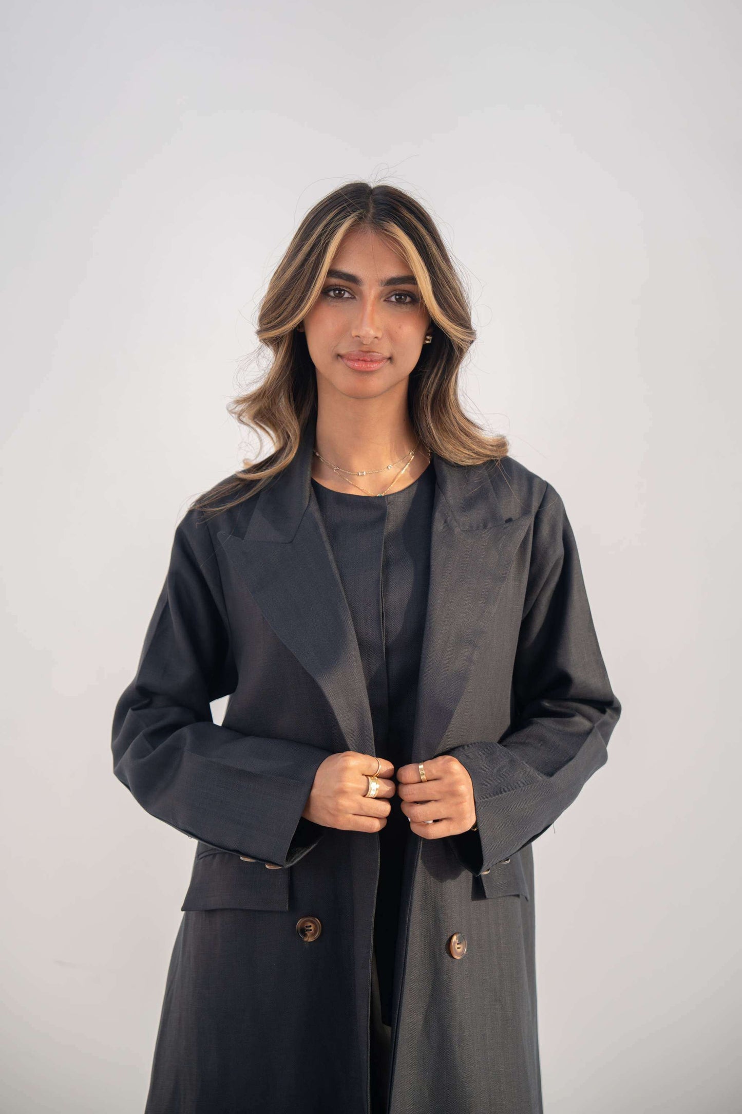 Navy blue blazer abaya with double-breasted buttons, sharp lapel collar, flap and hidden pockets, made from twill linen blend for a sleek and modern look.