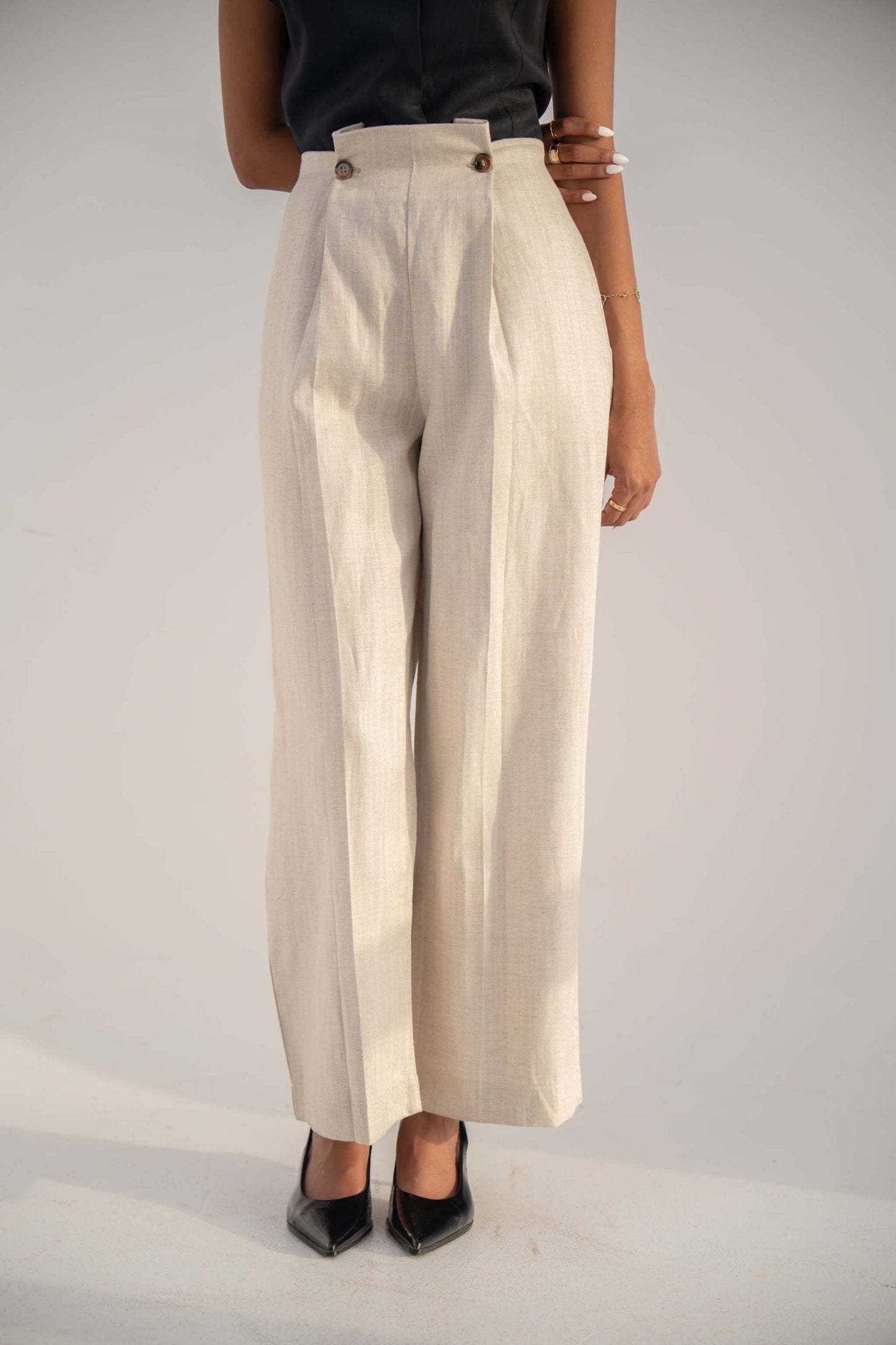Beige high-waisted Madeleine Pants in twill linen blend with relaxed straight-leg fit and button details.