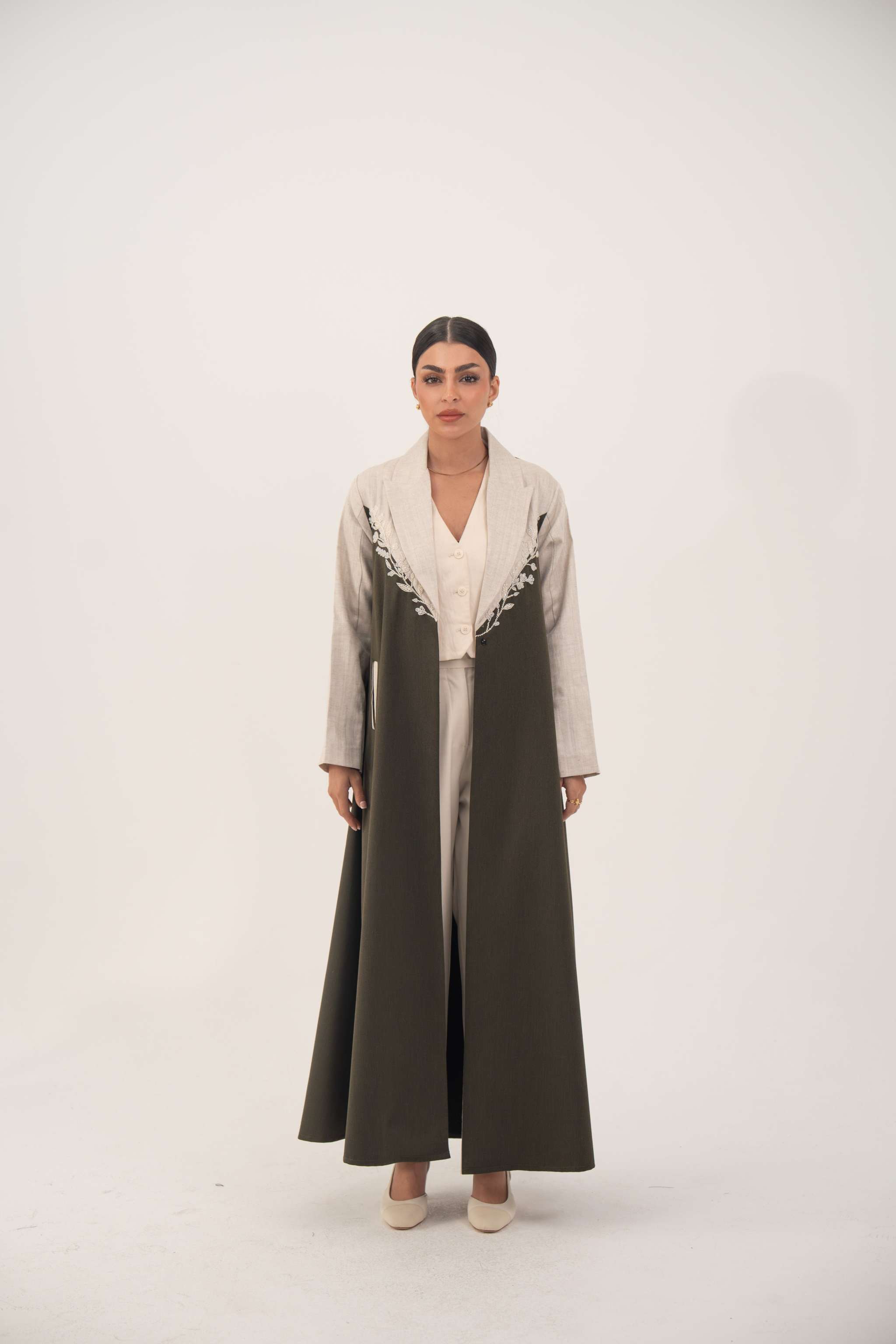 long olive green abaya with beige linen panels and white leaf embroidery on chest