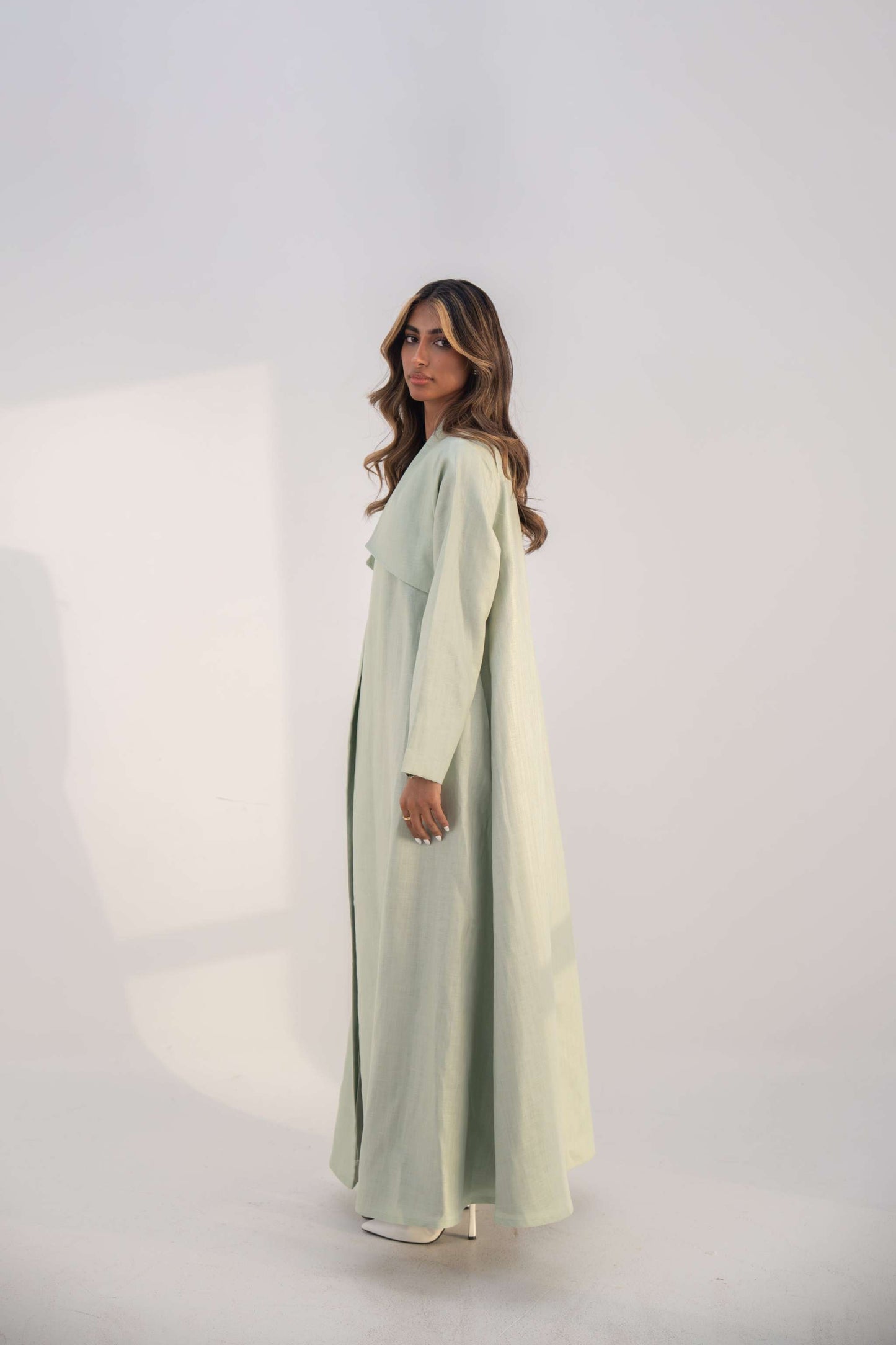 Mint green abaya crafted from soft twill linen blend with open front and draped collar for elegant layering