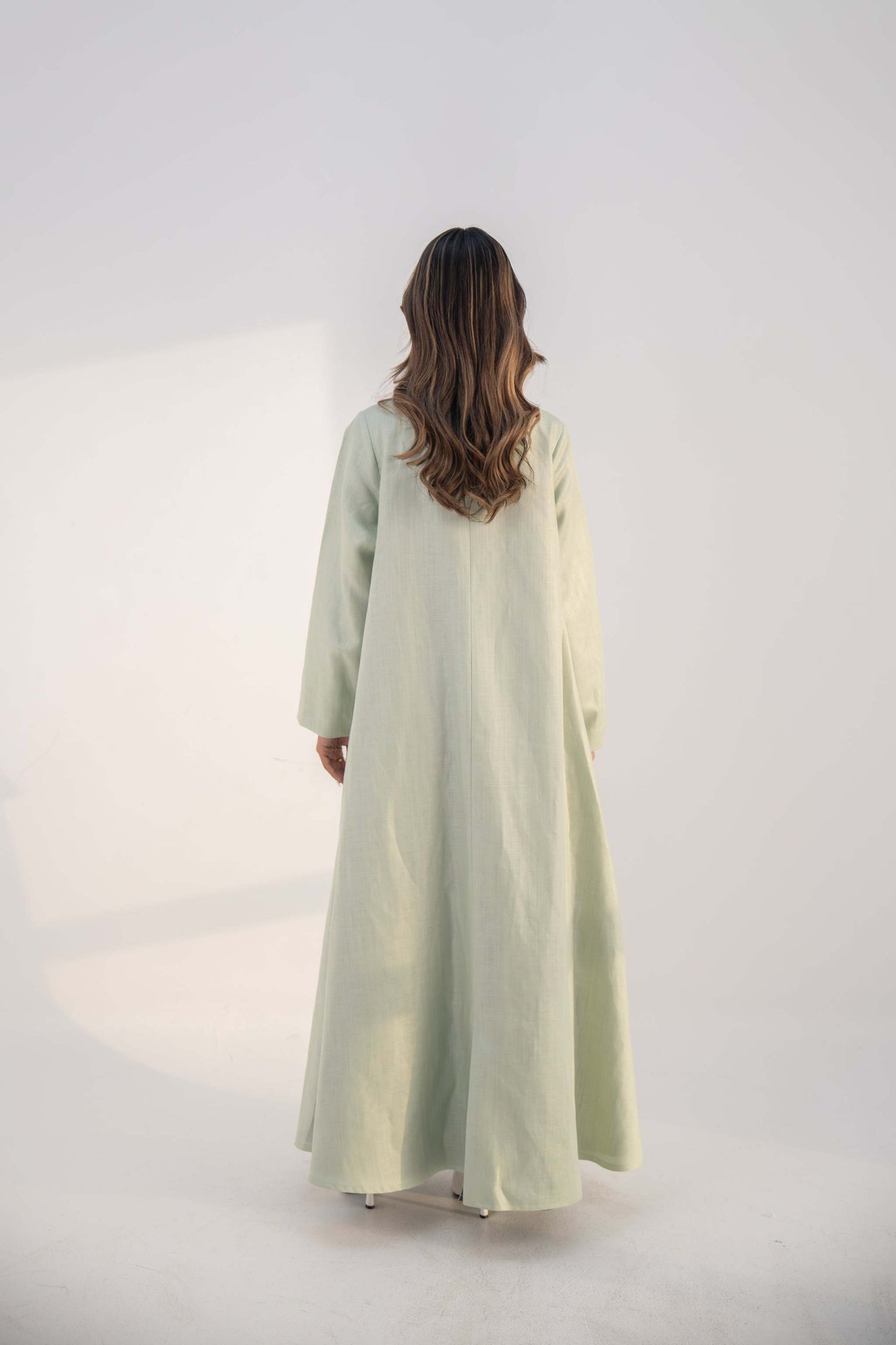 abaya crafted from soft twill linen blend in mint green with long, structured open-front design and draped collar