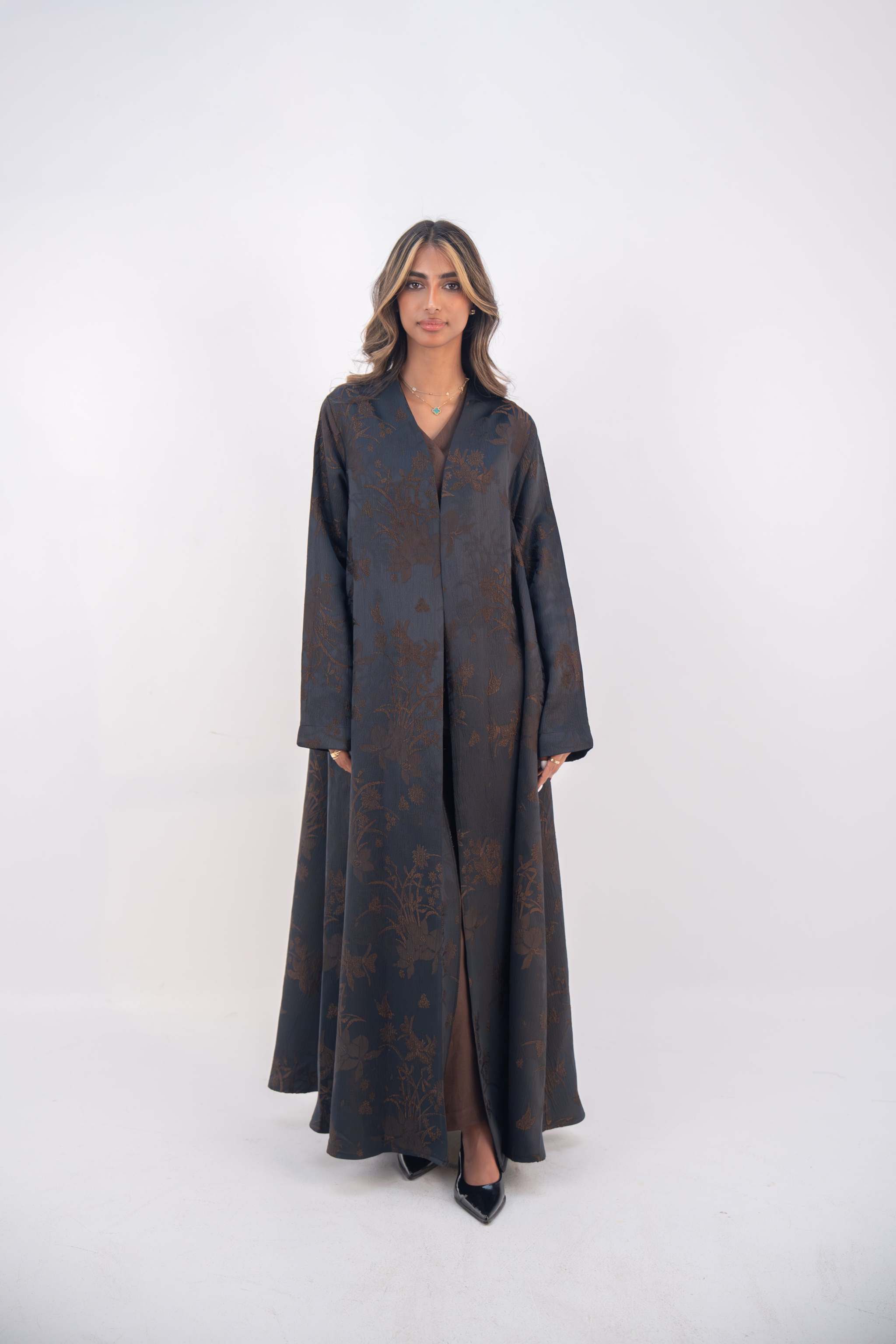 Elegant navy jacquard silk abaya with subtle brown floral patterns and wide sleeves.