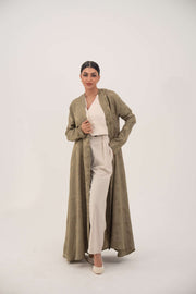 Woman wearing an elegant soft olive green silk abaya with collarless open front and ruched full-length sleeves.