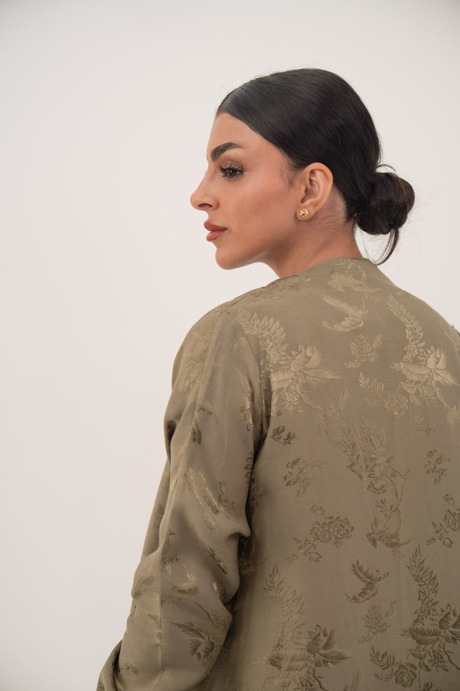 elegant olive green silk abaya with subtle floral pattern and full-length gathered sleeves