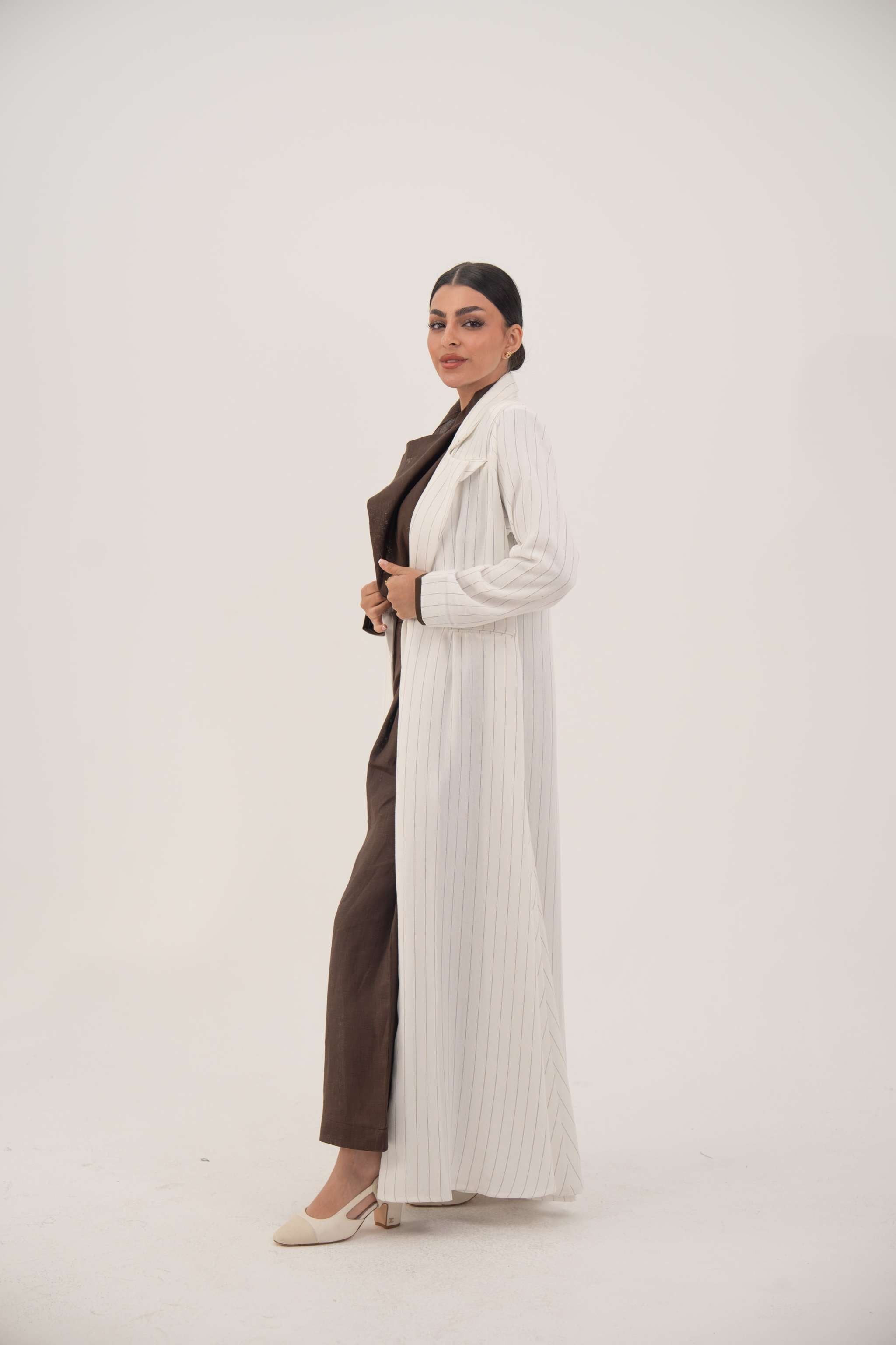 Elegant white linen abaya with grey pinstripes, blazer-inspired sharp lapel, single button, dark brown inner cuffs, and long flared hem - Elegant abaya