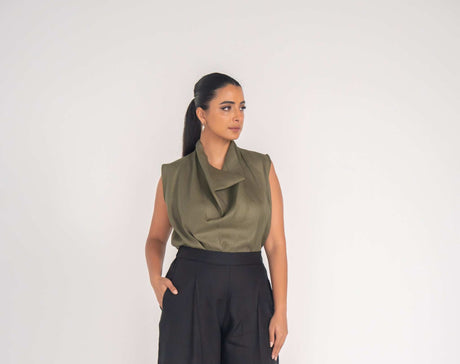 Woman wearing black Raya Pant made from 100% linen with a relaxed fit and olive green sleeveless top
