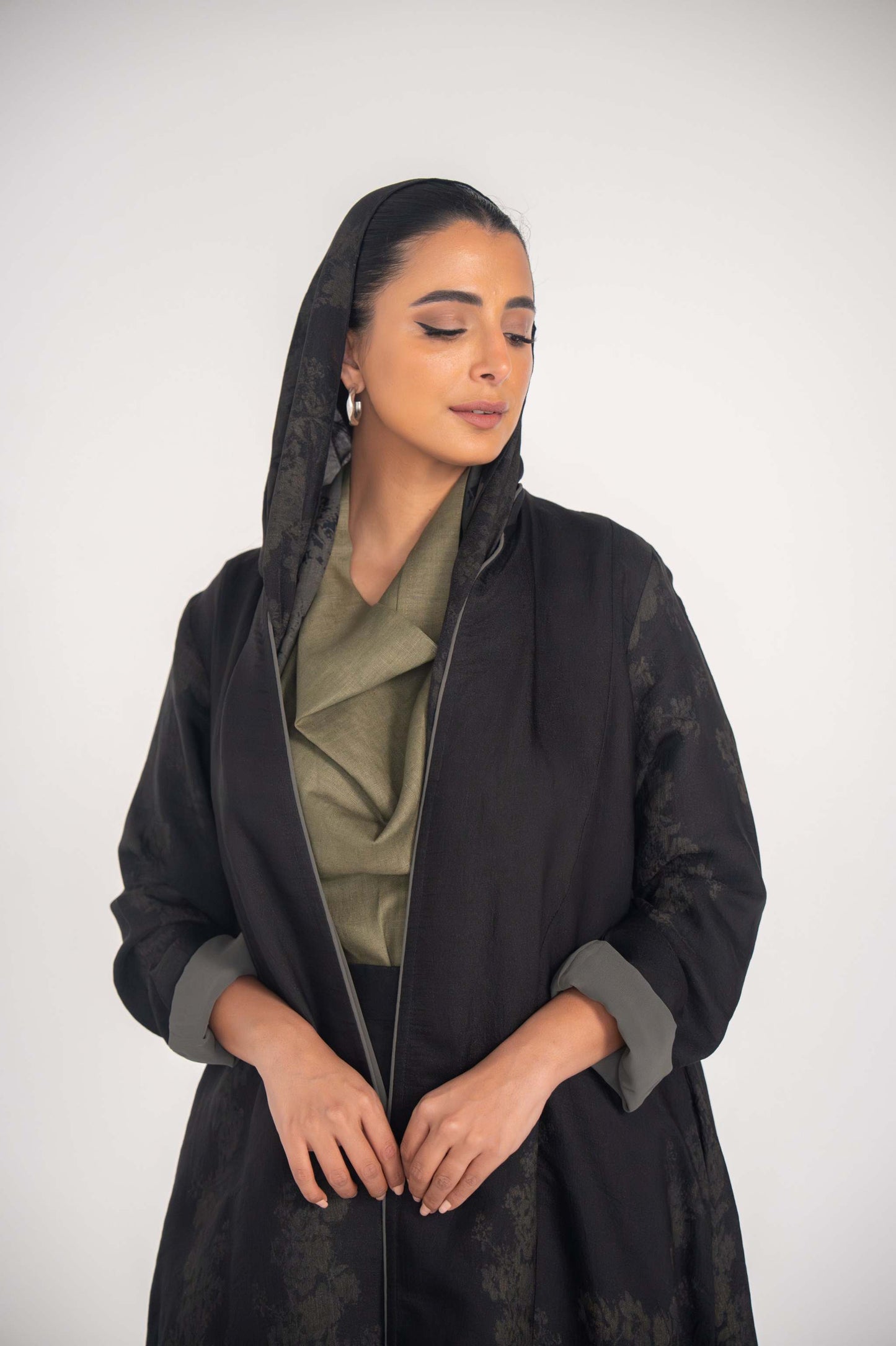 Black jacquard abaya with double closed cut, flowing silhouette, subtle floral pattern, grey cuff accents, and soft chiffon lining for elegant formal or everyday wear.