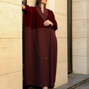 Woman wearing elegant red velvet abaya with luxurious hand embroidery and sunglasses outdoors