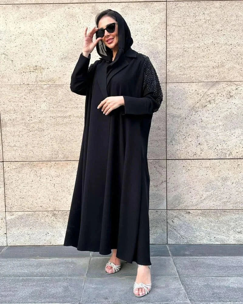 black crepe blazer abaya with tailored silhouette and hand embroidery on upper arms worn with sunglasses and sandals